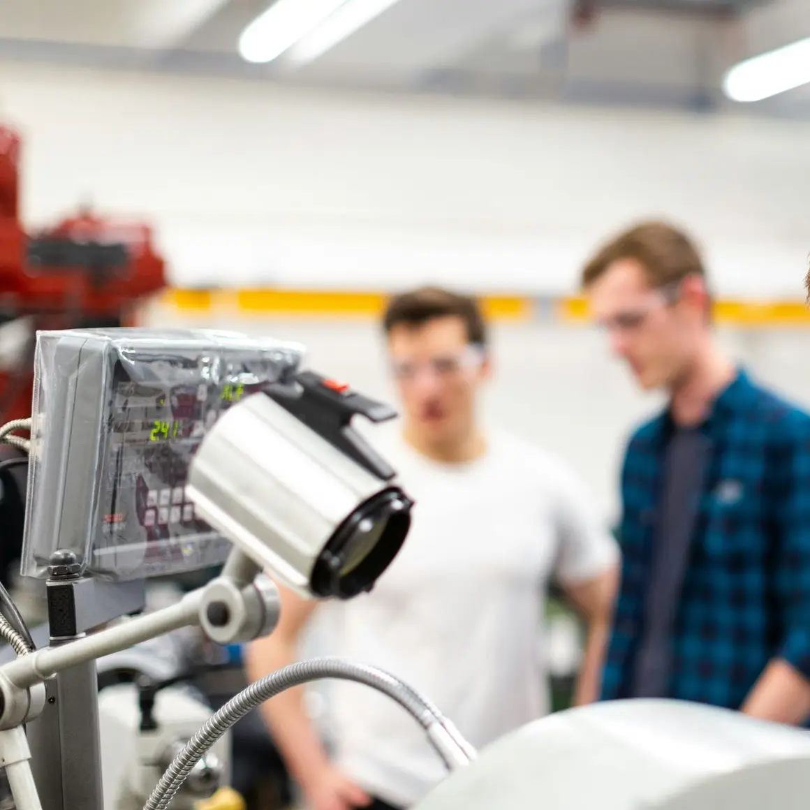 Technik mit menschen im Hintergrund
